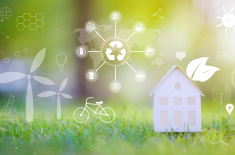 Grafika symbolizująca zrównoważony rozwój – na tle zielonej trawy widoczne są dom, rower, turbiny wiatrowe oraz ikony recyklingu, energii odnawialnej i ekologicznych technologii.